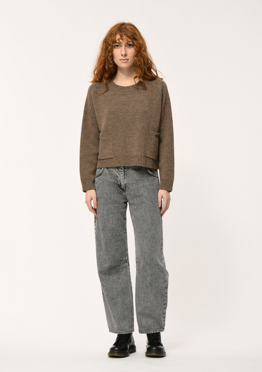 Femme portant un pull boxy taupe en maille doublée, coupe ample, avec poches plaquées sur le devant. Humility - HK-PU-KINKATA_728