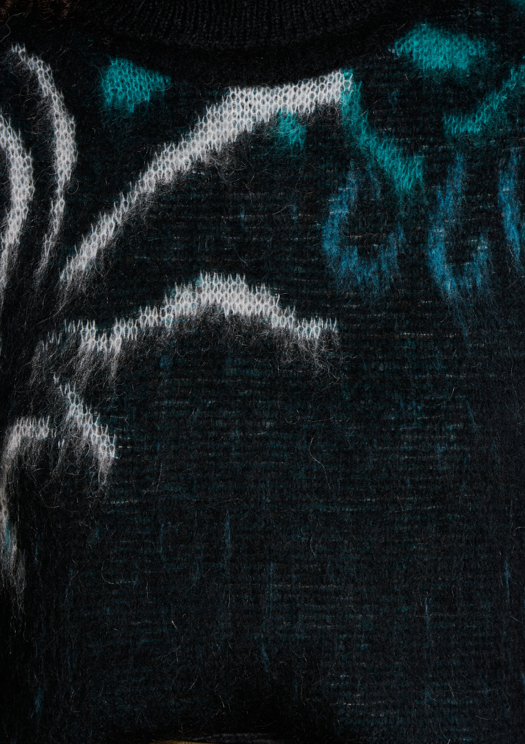 Gros plan sur la maille jacquard du pull, révélant les motifs végétaux en contraste bleu, noir et ivoire.
FK-PU-EZEPICE_1503 La Fée Maraboutée