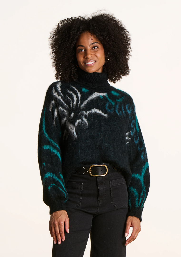 Pull noir à motifs jacquard végétaux avec manches bouffantes et col roulé, porté avec un pantalon noir et une ceinture.
FK-PU-EZEPICE_1503 La Fée Maraboutée