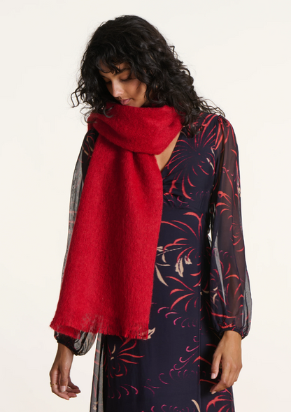 Femme portant une écharpe en mohair rouge vif autour du cou, assortie à une robe fluide à motifs.
FI-AT-ZLARINA_1727_-_Humility