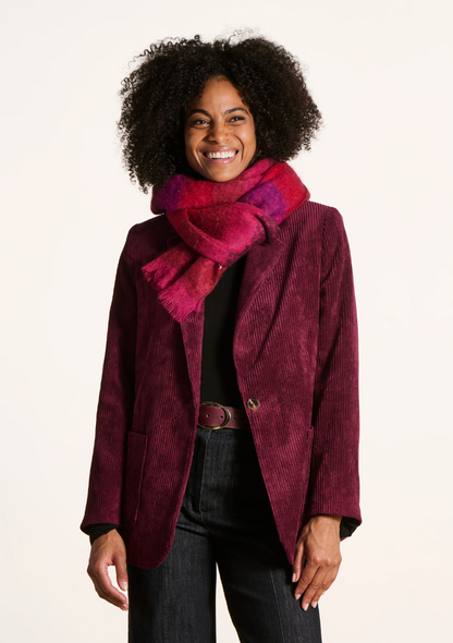 Femme souriante portant une écharpe rayée rouge et violette en mohair, avec une veste en velours côtelé bordeaux.
FK-AT-EZEKIEL_727 -_La_fee_maraboute