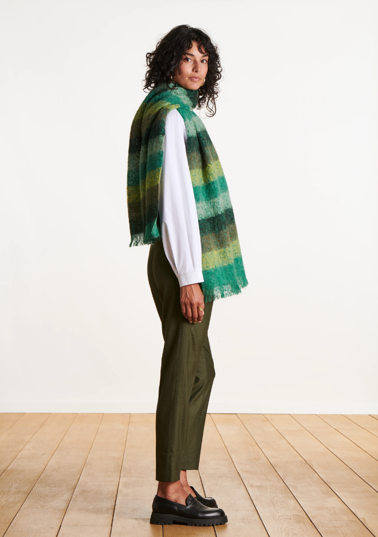 Vue de profil d’une femme portant l’écharpe rayée verte en mohair avec un pantalon vert olive.
FK-AT-EZEKIEL_709 - La fee maraboute
